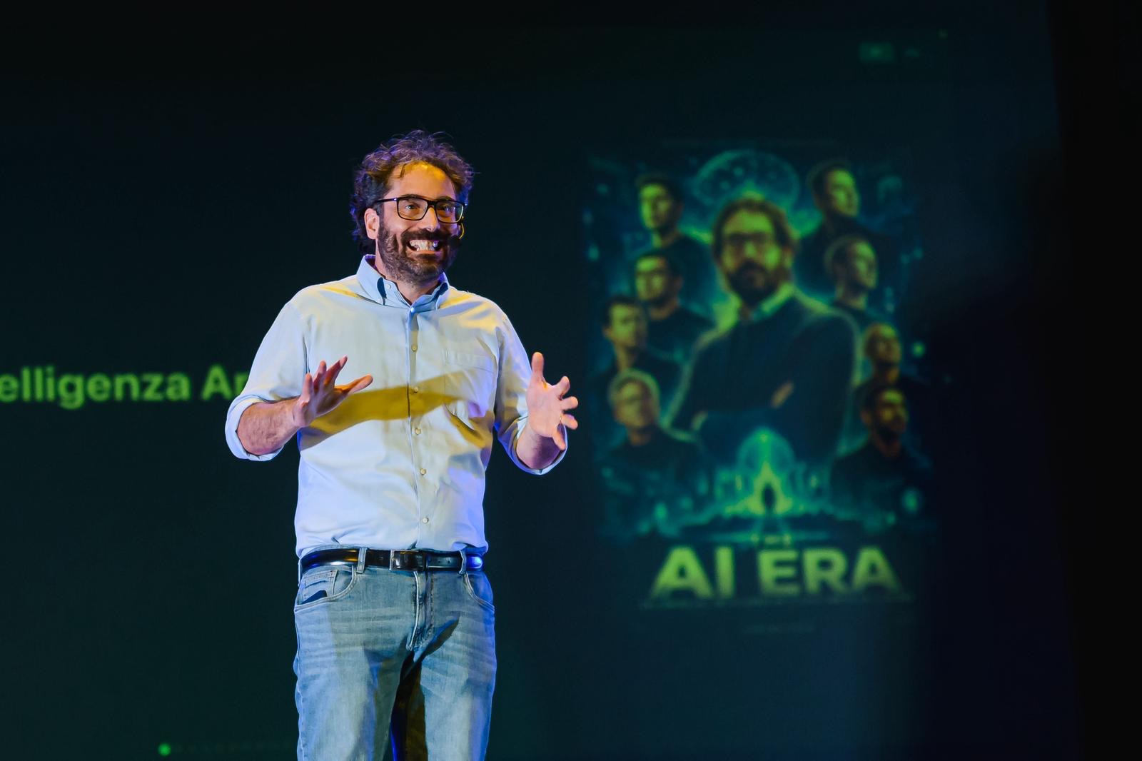 Mattia Crivellini sorride sul palco, dietro di lui la locandina di THE AI ERA proiettata